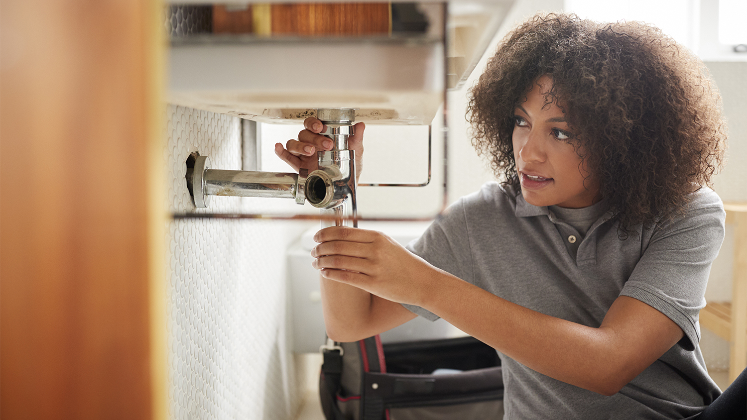 woman working on the plumbing in the bathroom     